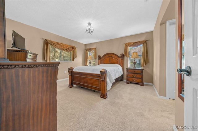 bedroom with multiple windows, light carpet, and baseboards