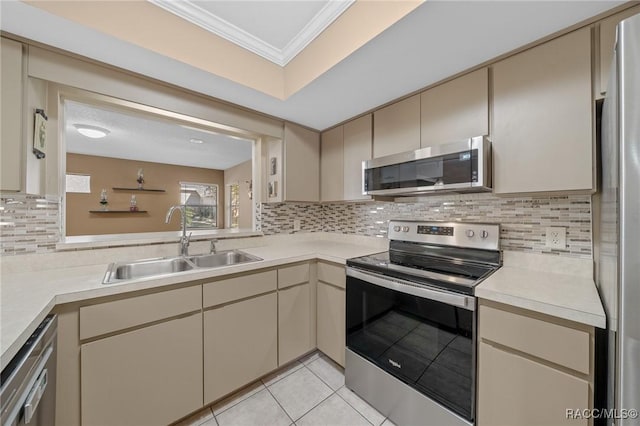 kitchen featuring light countertops, cream cabinetry, appliances with stainless steel finishes, and a sink