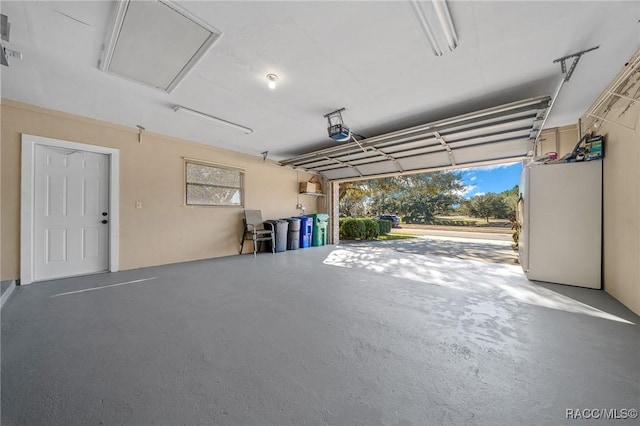 garage with refrigerator and a garage door opener