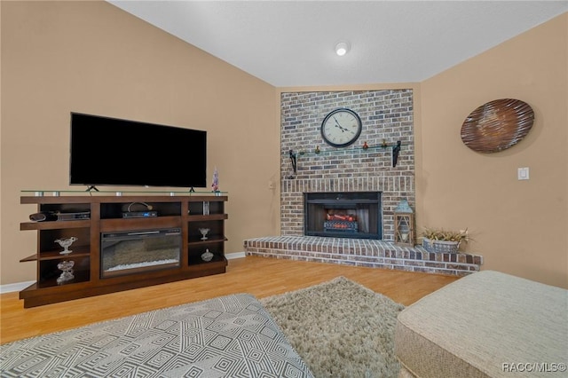 living room featuring wood finished floors, a fireplace, and baseboards