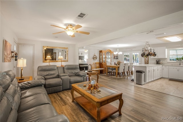 living room with a healthy amount of sunlight, sink, ceiling fan, and light hardwood / wood-style floors