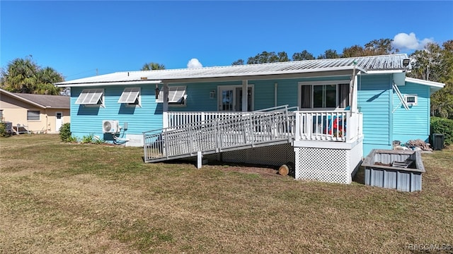 rear view of property with a lawn and a wooden deck