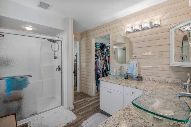 bathroom with wooden walls, hardwood / wood-style floors, and a shower with door