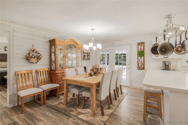 dining space featuring hardwood / wood-style floors, a chandelier, and french doors