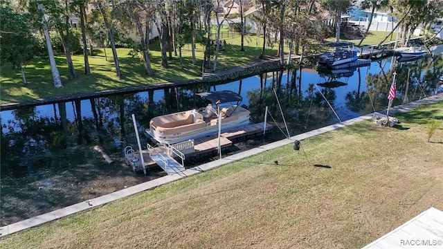 view of dock with a yard and a water view