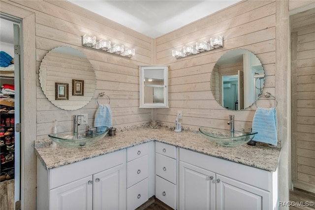 bathroom with wooden walls, vanity, and hardwood / wood-style flooring