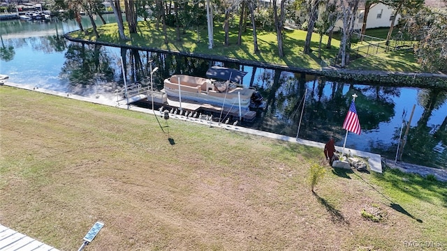 dock area with a water view and a yard