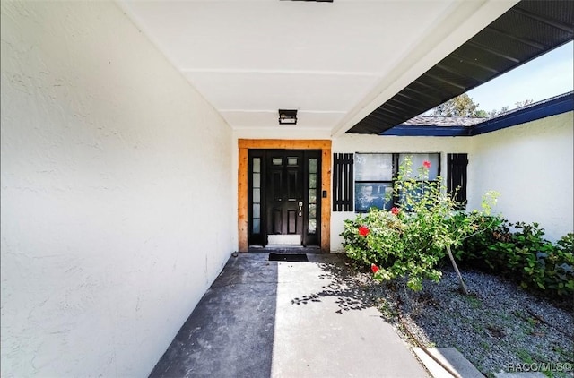 doorway to property featuring stucco siding
