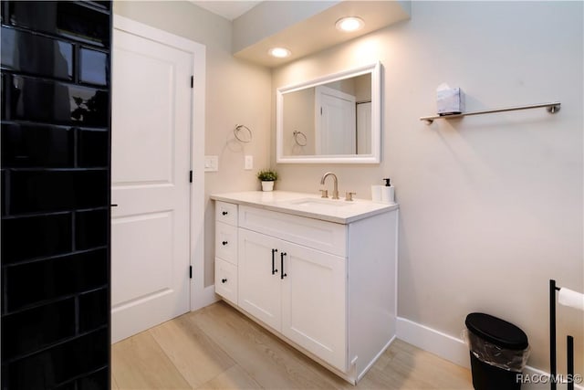 bathroom featuring baseboards, vanity, and wood finished floors