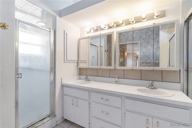 bathroom featuring decorative backsplash, a shower with door, and vanity