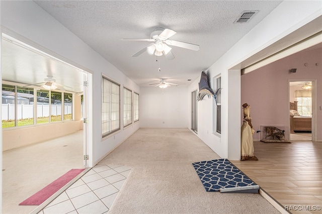 hallway featuring light hardwood / wood-style floors and a textured ceiling