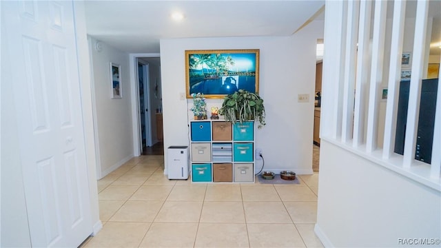 interior space with baseboards and light tile patterned floors