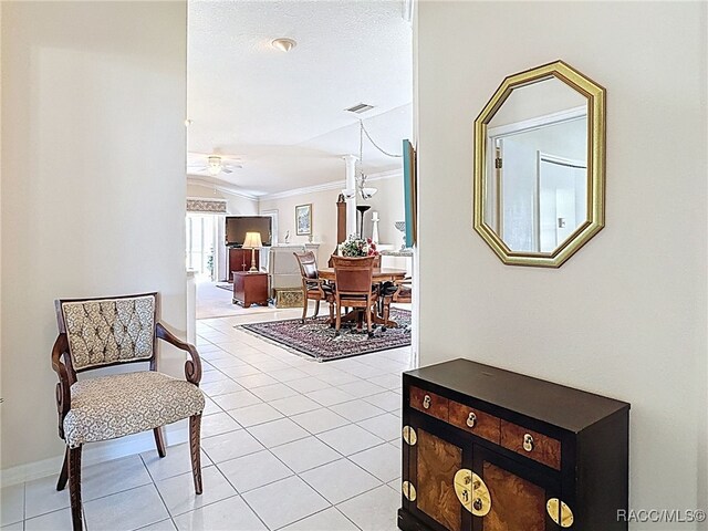 entryway featuring light tile patterned floors, crown molding, and a healthy amount of sunlight