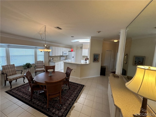 tiled dining room with vaulted ceiling with skylight and ornamental molding