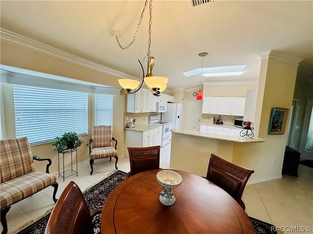 dining space with light tile patterned floors, vaulted ceiling with skylight, crown molding, and a chandelier