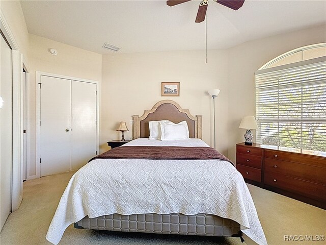 bedroom with ceiling fan, light colored carpet, and lofted ceiling