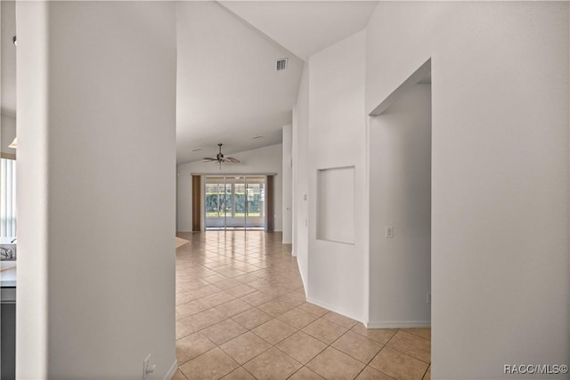 hallway with vaulted ceiling and light tile patterned floors