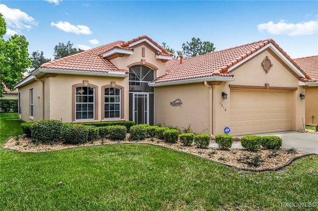 mediterranean / spanish-style home featuring a garage and a front yard