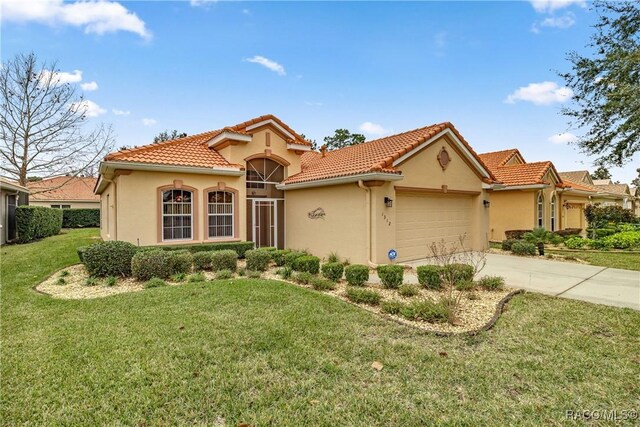 mediterranean / spanish home with a garage and a front lawn