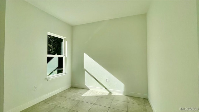 unfurnished room featuring baseboards and light tile patterned flooring