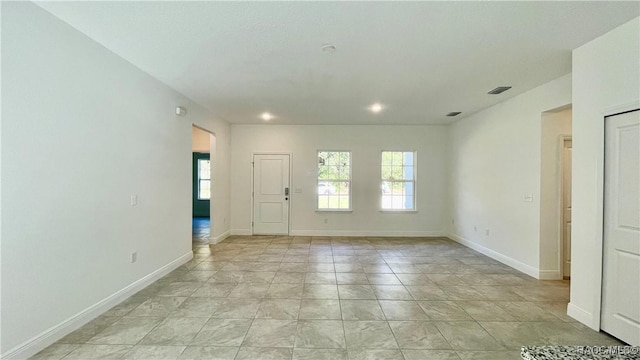 empty room featuring recessed lighting, visible vents, and baseboards