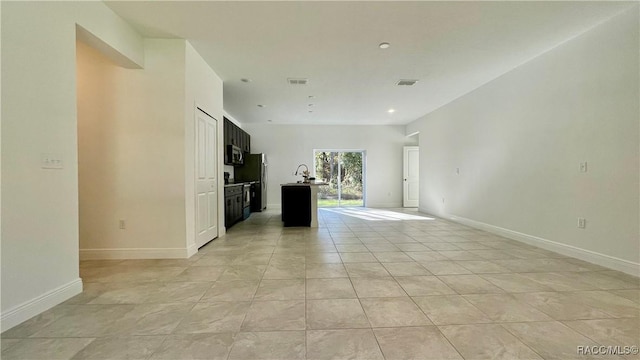 unfurnished living room featuring light tile patterned flooring, visible vents, and baseboards