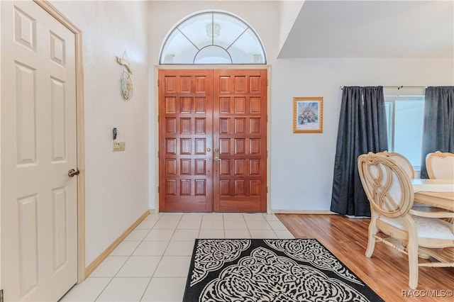 foyer entrance with light tile patterned floors and a wealth of natural light