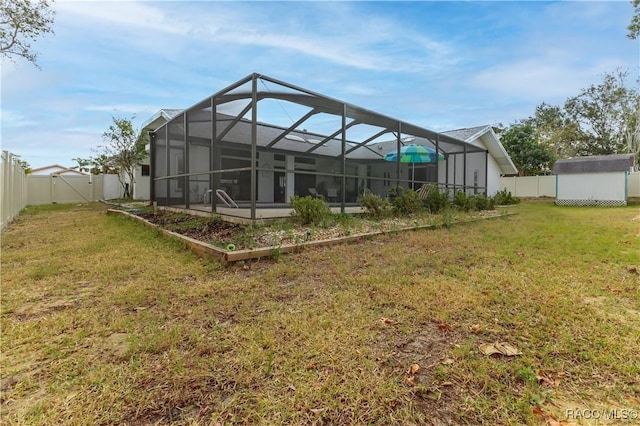 back of house featuring a storage unit, glass enclosure, and a lawn