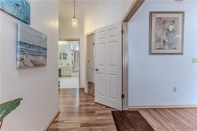 corridor featuring hardwood / wood-style flooring and a towering ceiling