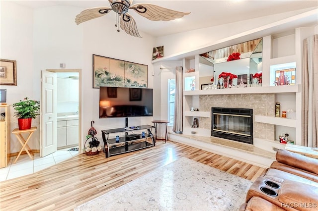 living room with hardwood / wood-style flooring, ceiling fan, and a high ceiling