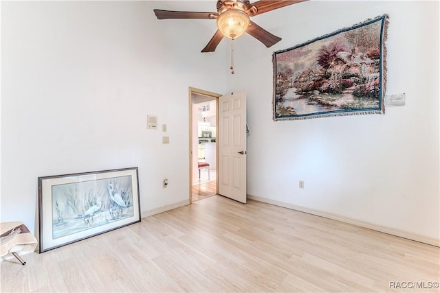 empty room with ceiling fan and light hardwood / wood-style floors