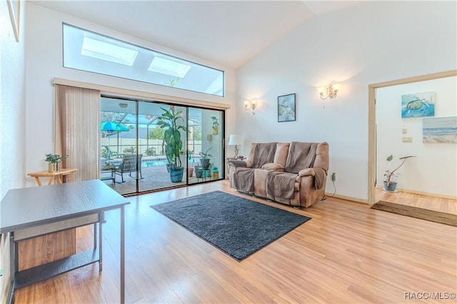 living room with high vaulted ceiling and light hardwood / wood-style flooring