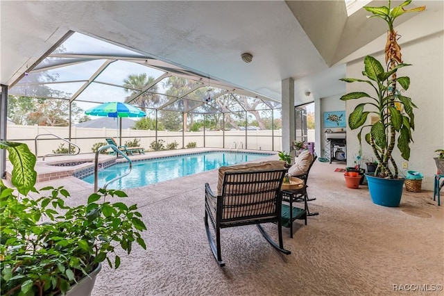 view of swimming pool with an in ground hot tub, glass enclosure, and a patio area