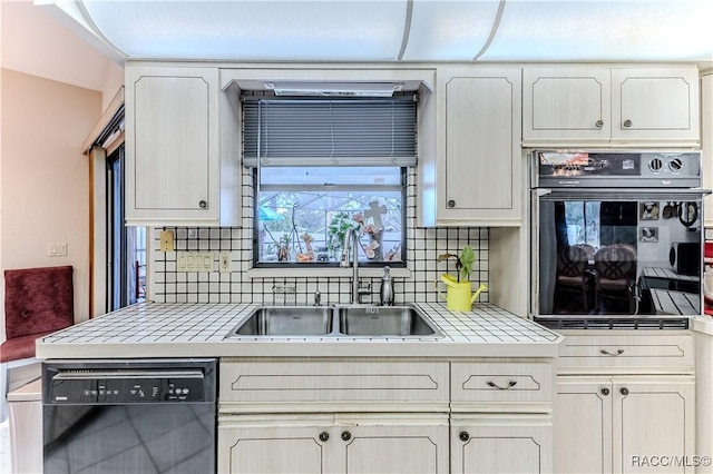 kitchen with sink, decorative backsplash, tile countertops, and black appliances