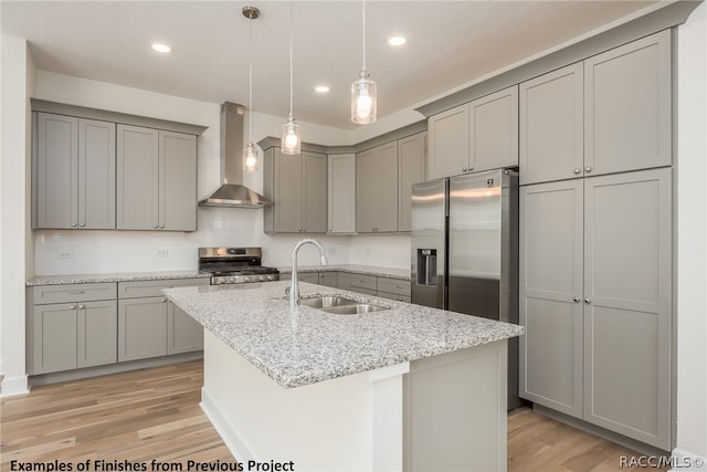 kitchen with light hardwood / wood-style flooring, stainless steel appliances, wall chimney range hood, and sink