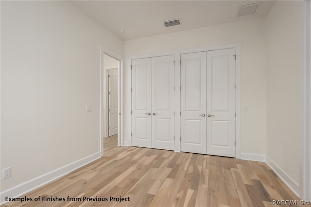 unfurnished bedroom featuring light hardwood / wood-style flooring and two closets