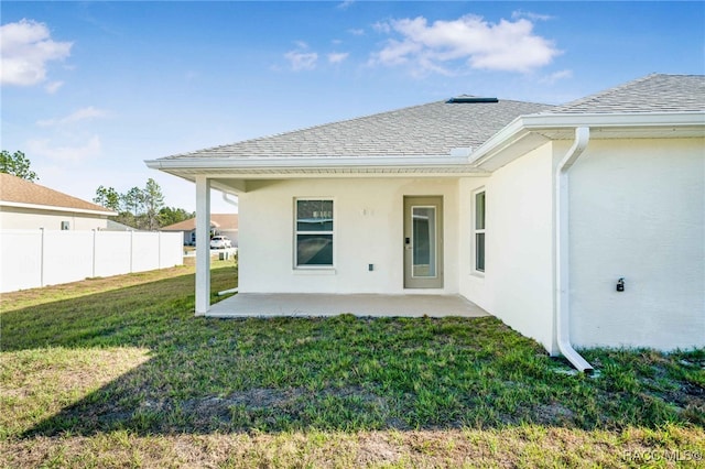 rear view of house featuring a patio area and a lawn