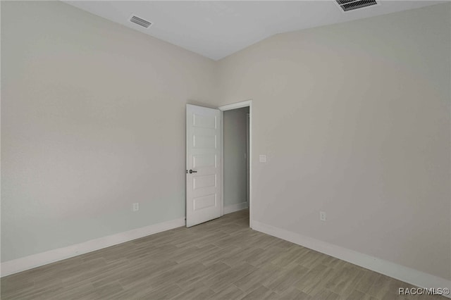 empty room with lofted ceiling and light wood-type flooring