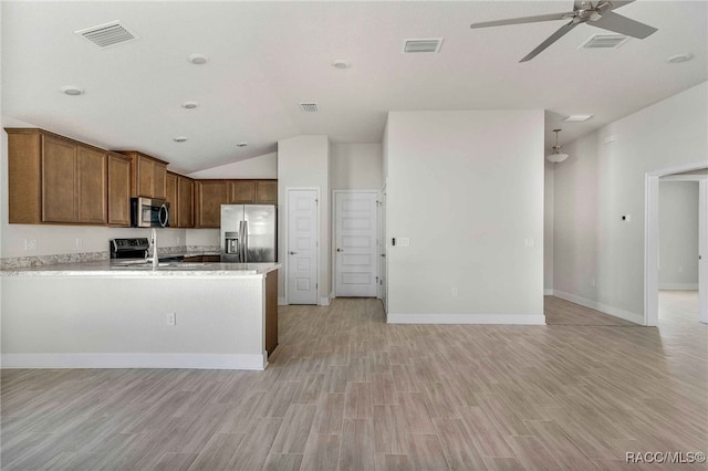 kitchen featuring sink, vaulted ceiling, light hardwood / wood-style flooring, appliances with stainless steel finishes, and ceiling fan