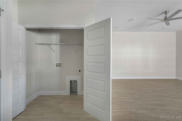 laundry area with ceiling fan, electric dryer hookup, washer hookup, a barn door, and light wood-type flooring