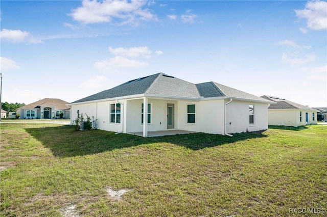 rear view of property featuring a patio and a yard