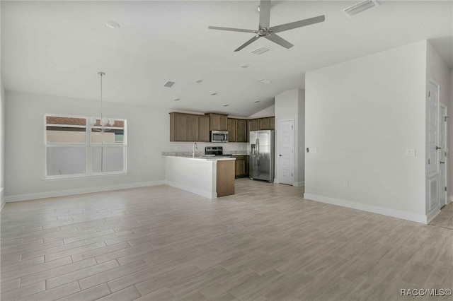 unfurnished living room with lofted ceiling, sink, ceiling fan with notable chandelier, and light hardwood / wood-style floors