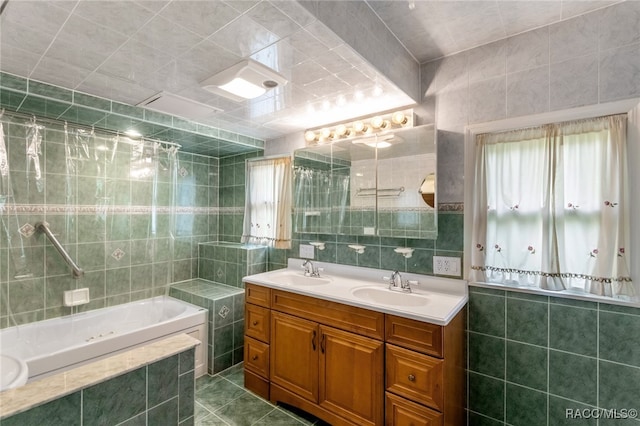 bathroom with vanity, tiled bath, and tile walls