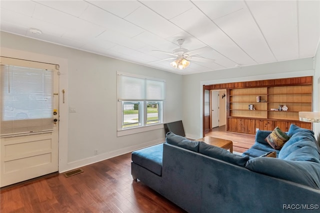 living room featuring ceiling fan and dark hardwood / wood-style flooring