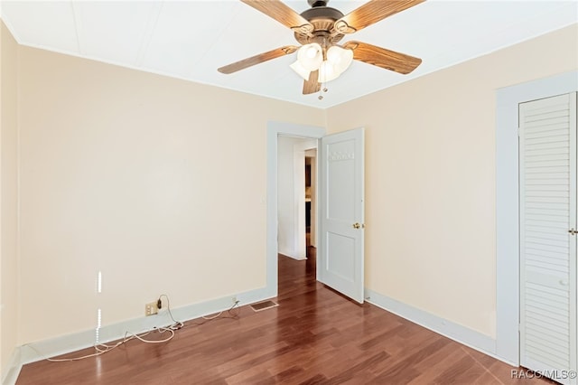 unfurnished bedroom with ceiling fan, a closet, and dark hardwood / wood-style floors