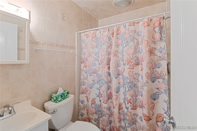 bathroom with a shower with curtain, vanity, toilet, and tile walls