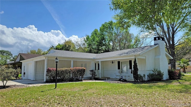 single story home with a front lawn, covered porch, and a garage