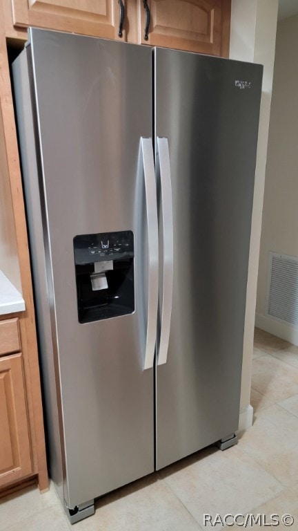 room details with stainless steel refrigerator with ice dispenser and light brown cabinetry