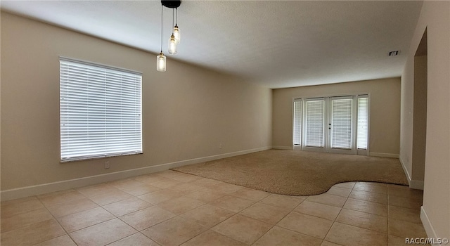 interior space featuring french doors, light tile patterned floors, and a textured ceiling