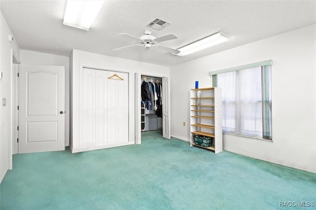 unfurnished bedroom featuring carpet, a textured ceiling, and ceiling fan